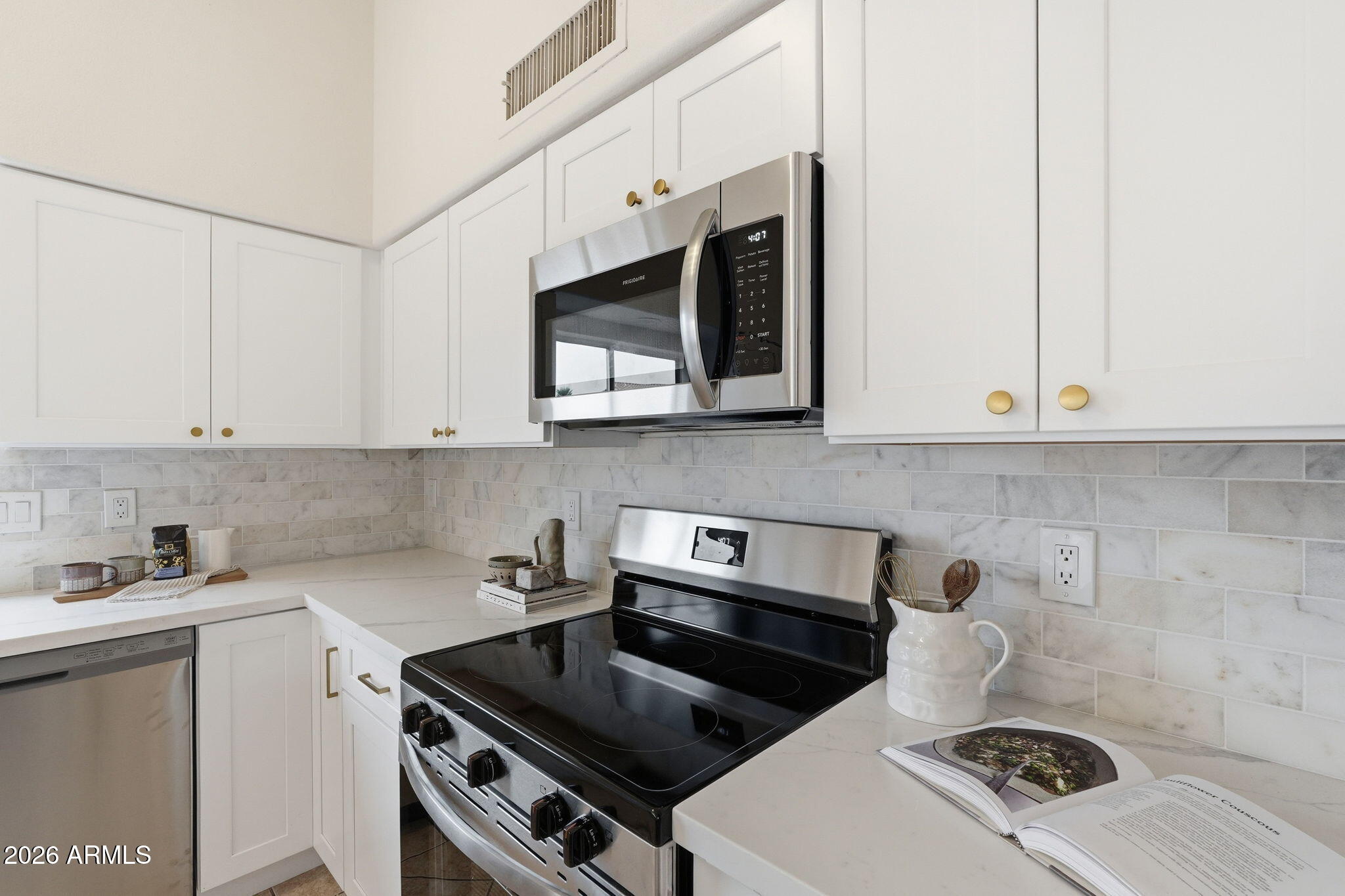 7756 West Hearn Road Peoria, AZ 85381 - Photo 17 of 41 a kitchen with stainless steel appliances a white stove top oven and cabinets