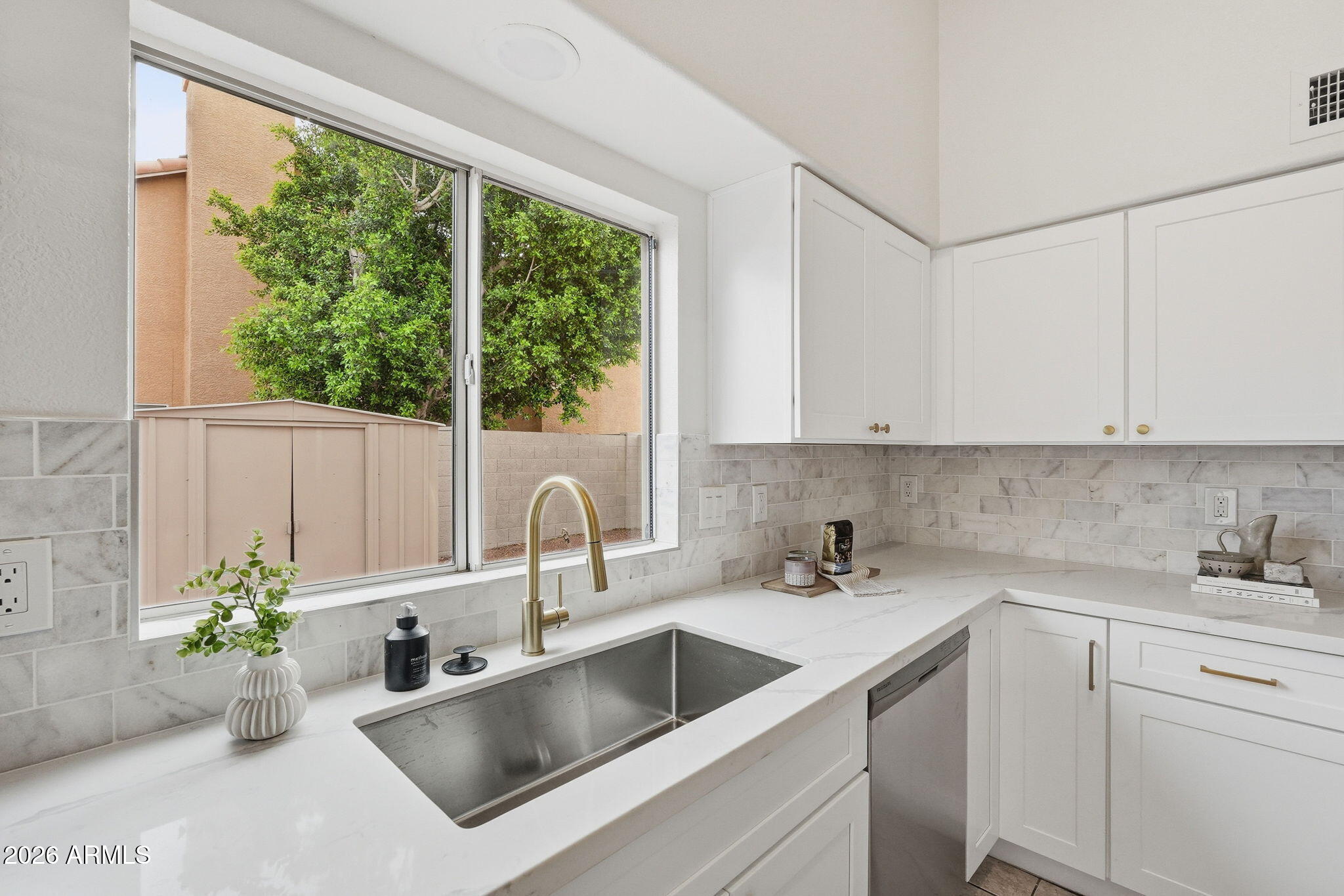 7756 West Hearn Road Peoria, AZ 85381 - Photo 18 of 41 a kitchen with a potted plant on the counter and a sink