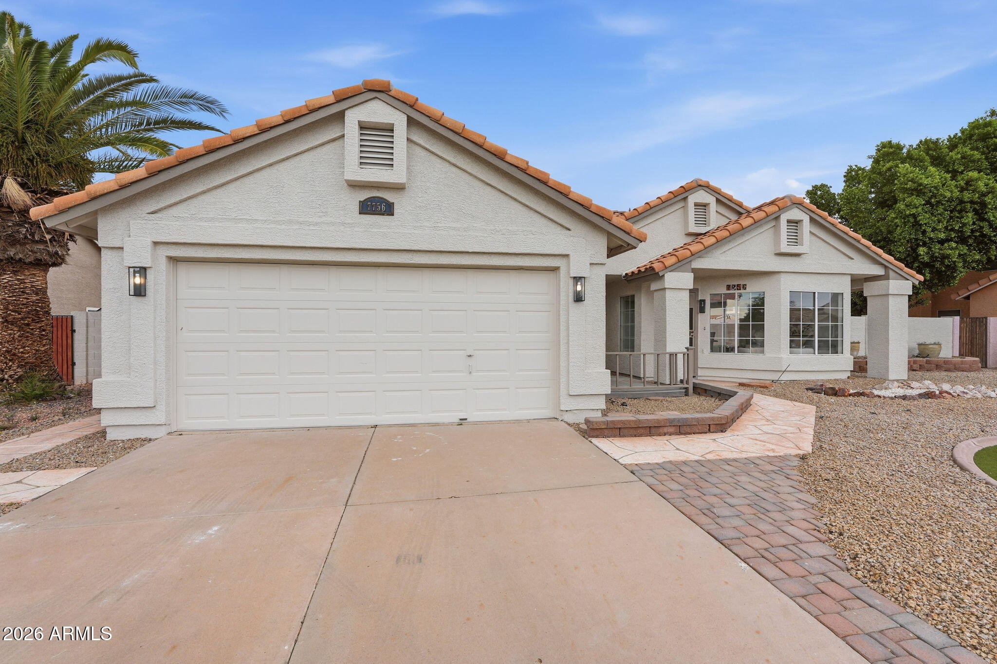 7756 West Hearn Road Peoria, AZ 85381 - Photo 4 of 41 a front view of a house with a yard and garage