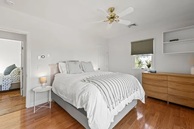 a bedroom with a bed chandelier and a window