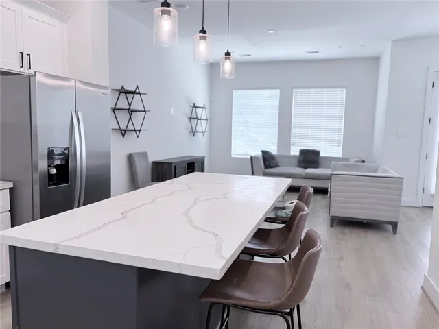 a kitchen with stainless steel appliances a table chairs and refrigerator