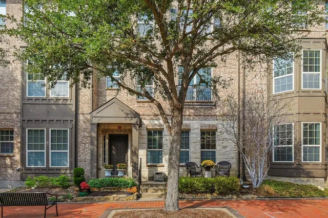 front view of a brick house with a tree