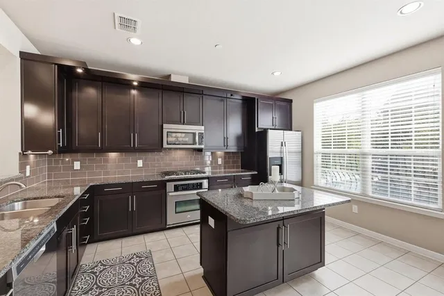 a kitchen with a sink stainless steel appliances and cabinets