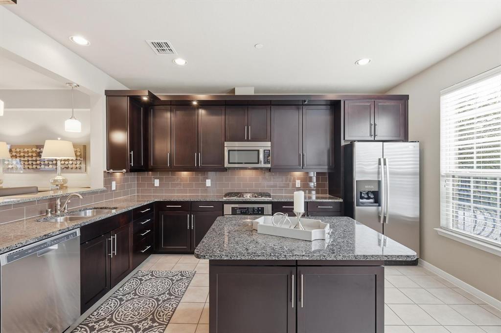 3941 Asbury Lane Addison, TX 75001 - Photo 17 of 30 a kitchen with stainless steel appliances granite countertop a sink a stove a refrigerator and cabinets