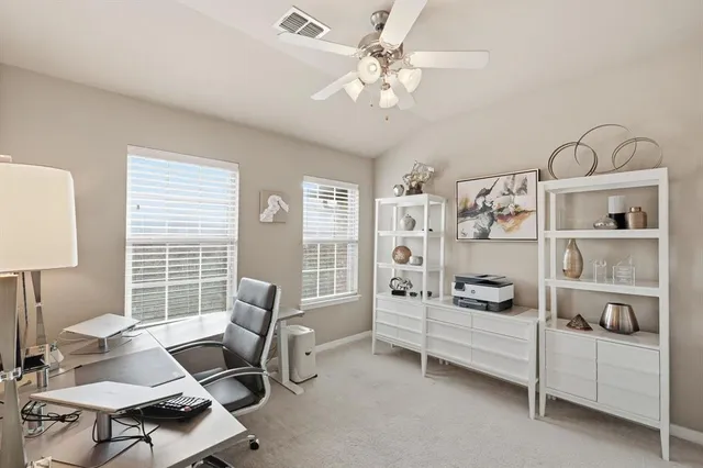 a view of a workspace with furniture and a window