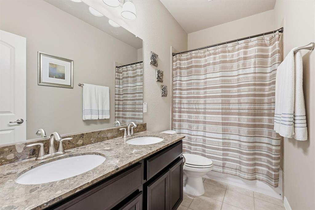 3941 Asbury Lane Addison, TX 75001 - Photo 25 of 30 a bathroom with a granite countertop sink toilet and shower