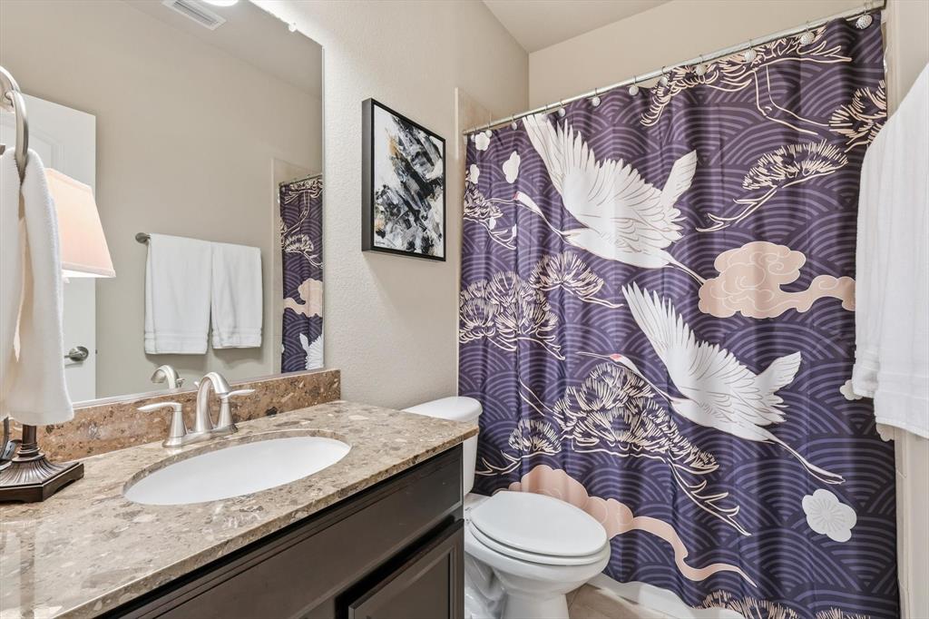 3941 Asbury Lane Addison, TX 75001 - Photo 5 of 30 a bathroom with a granite countertop toilet sink and mirror
