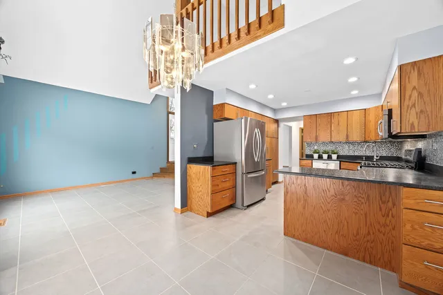 a large kitchen with stainless steel appliances granite countertop a lot of counter space and a window