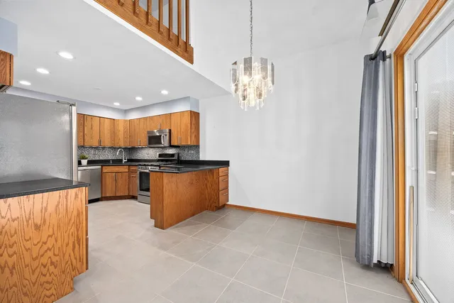 a view of kitchen with granite countertop stainless steel appliances and a window