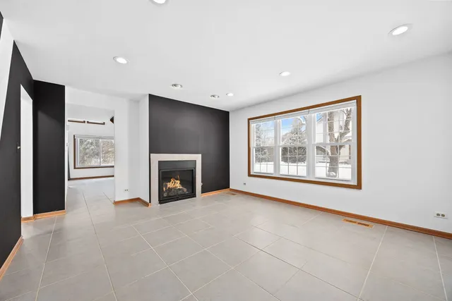 a view of an empty room with a window and a fireplace