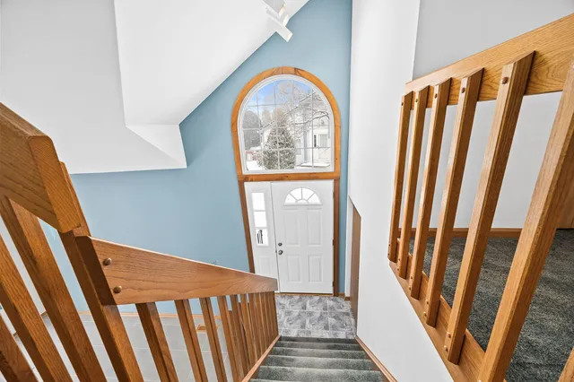 a view of staircase with railing and white walls