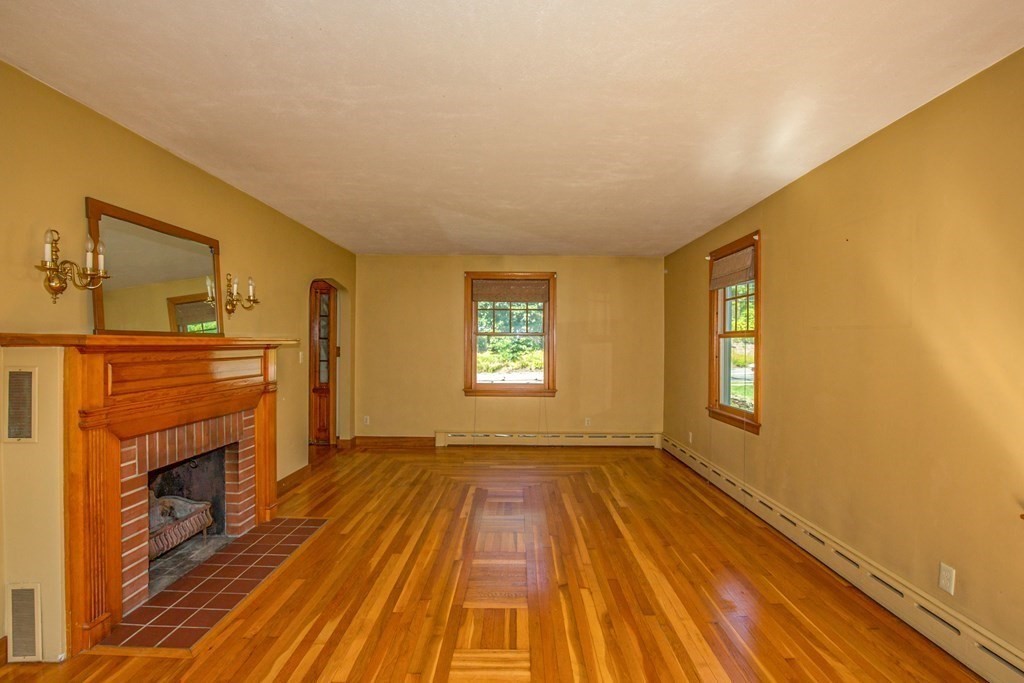 25 Belchertown Street Three Rivers, MA 01080 - Photo 11 of 32 a view of a livingroom with wooden floor and a fireplace