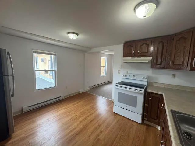 a kitchen with granite countertop a stove a sink and a refrigerator
