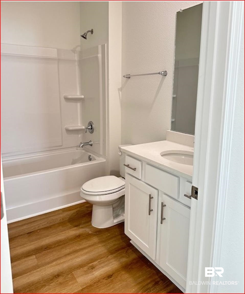 13906 Antler Hl Road Daphne, AL 36527 - Photo 9 of 23 Full bathroom with toilet, vanity, hardwood / wood-style flooring, and bathing tub / shower combination