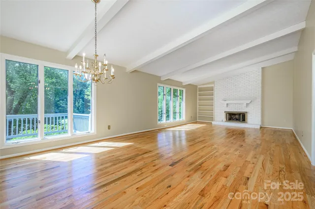 a view of empty room with wooden floor and fireplace