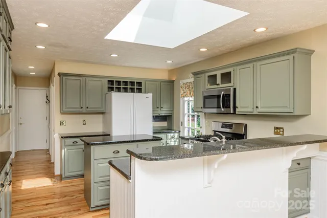 a kitchen with stainless steel appliances granite countertop a sink stove and cabinets