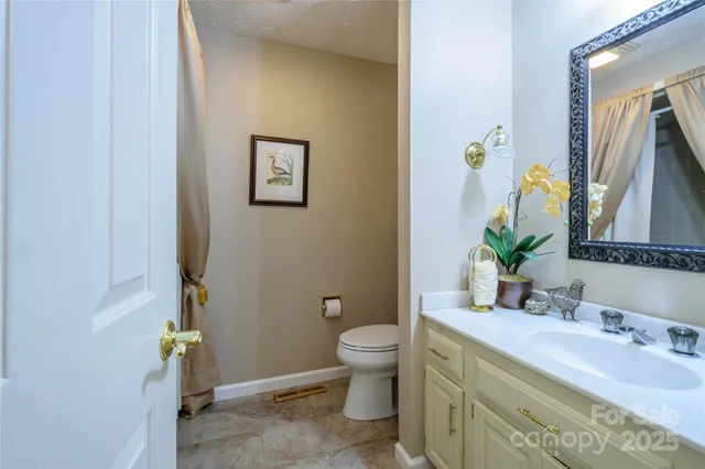 a bathroom with a granite countertop sink a toilet and a mirror