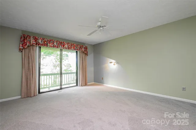 an empty room with a ceiling fan and a window