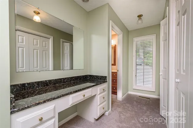 a bathroom with a double vanity sink toilet and a window