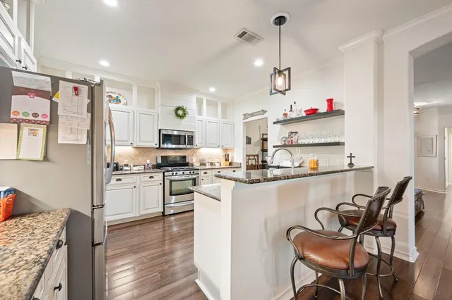 a kitchen with kitchen island granite countertop a sink cabinets and stainless steel appliances