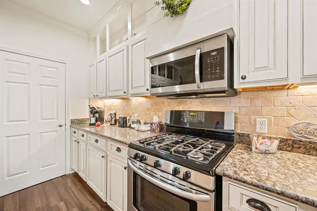a kitchen with granite countertop a stove and a sink