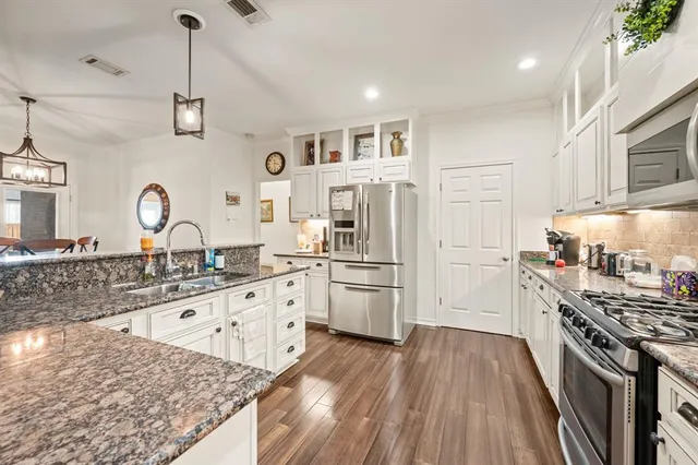 a kitchen with stainless steel appliances granite countertop a sink stove and refrigerator