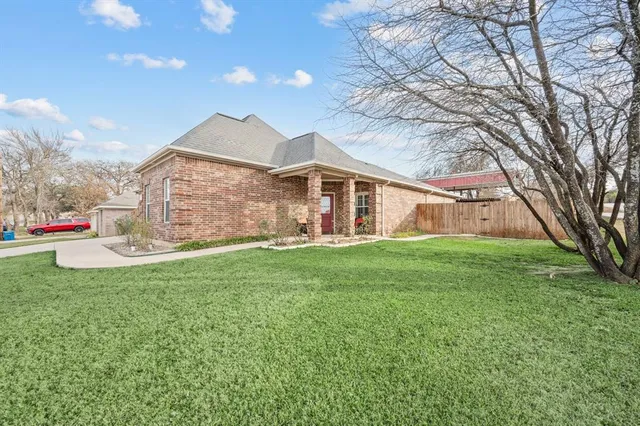 a front view of a house with a garden and plants