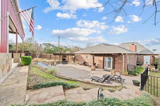 a view of a patio with couches table and chairs under an umbrella