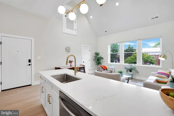 a kitchen with stainless steel appliances a sink a stove oven a refrigerator with white cabinets