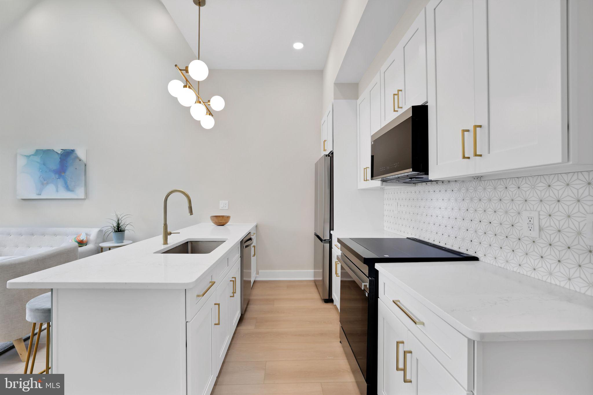 4019 9th Street Northeast, Unit 1 Washington, DC 20017 - Photo 12 of 27 a kitchen with stainless steel appliances a sink a stove oven a refrigerator with white cabinets