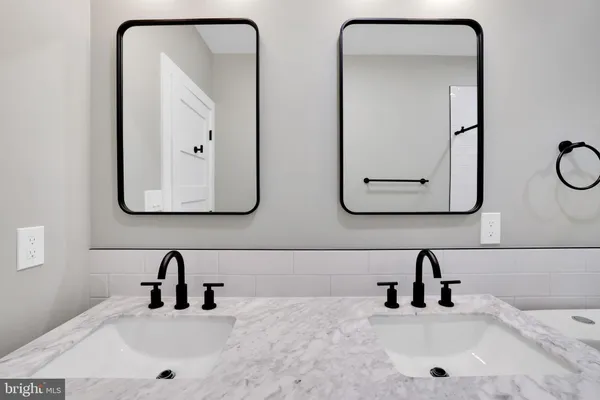 a bathroom with a double vanity sink toilet mirror and shower