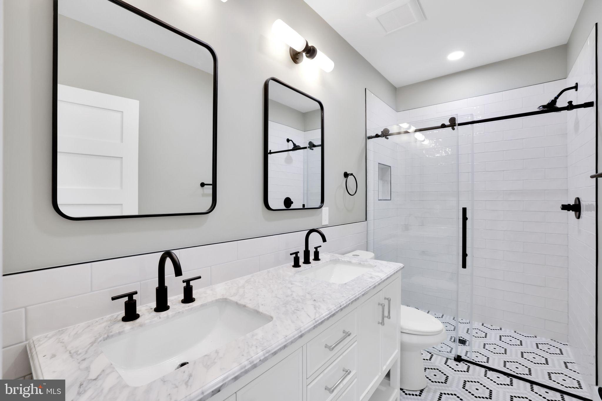 4019 9th Street Northeast, Unit 1 Washington, DC 20017 - Photo 17 of 27 a bathroom with a double vanity sink toilet mirror and shower