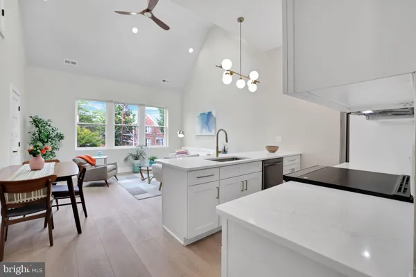 a living room with stainless steel appliances kitchen island furniture and a chandelier
