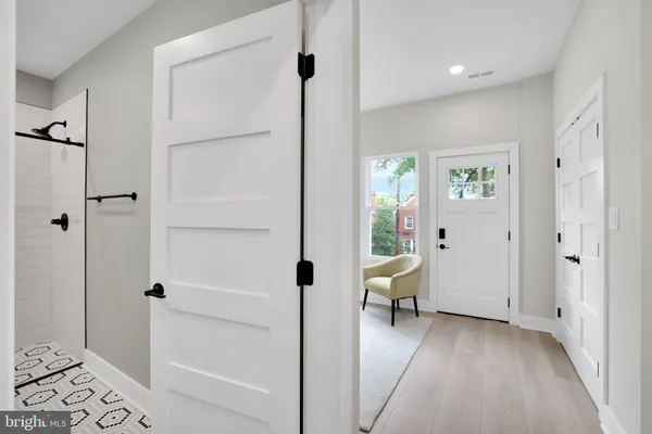 a view of a hallway with bathroom and wooden floor