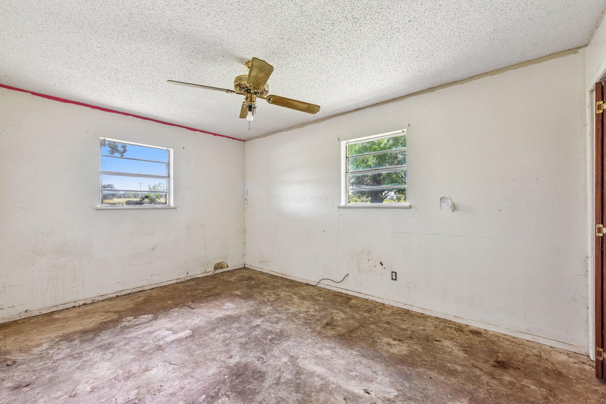 1111 Silent Valley Road Lockhart, TX 78644 - Photo 10 of 14 Bright windows and a classic ceiling fan enhance this spacious, well-lit room.