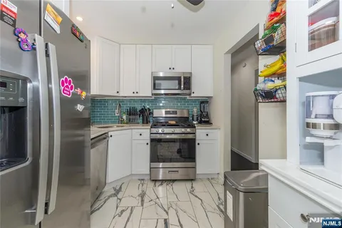 a kitchen with granite countertop a stove and a refrigerator