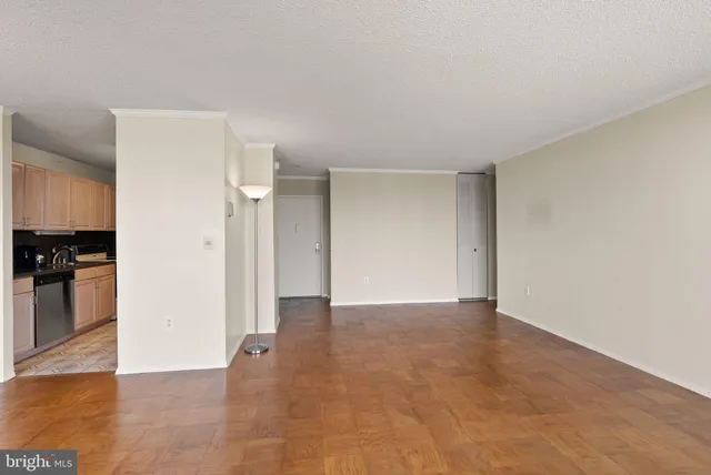 a view of an empty room with wooden floor and a cabinet