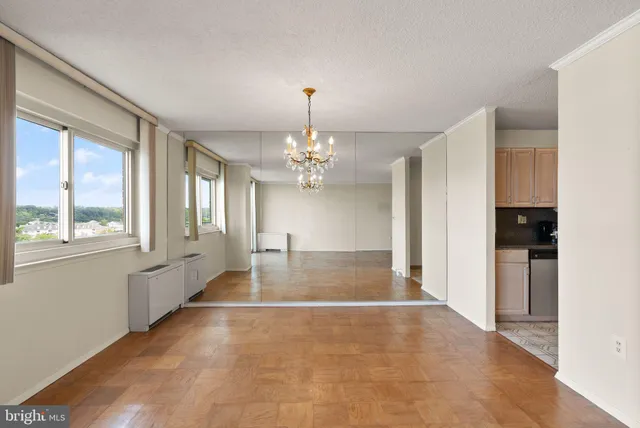 a view of an empty room with window and cabinet
