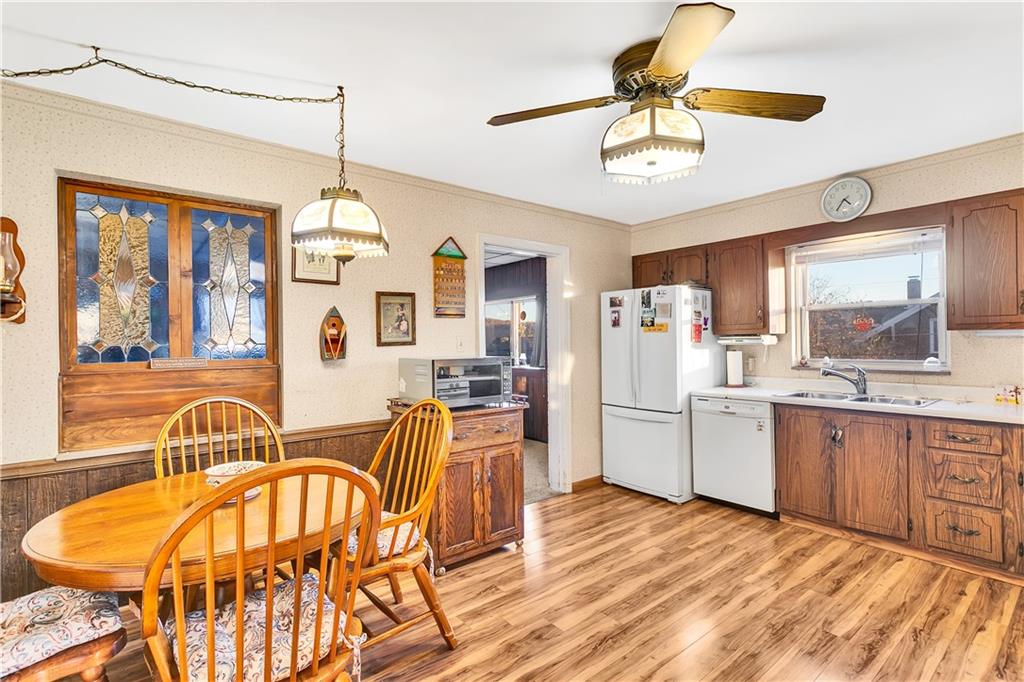 600 Colfax Street Springdale, PA 15144 - Photo 8 of 18 a kitchen with stainless steel appliances kitchen island granite countertop a refrigerator a stove a sink dishwasher with a dining table and chairs with wooden floor