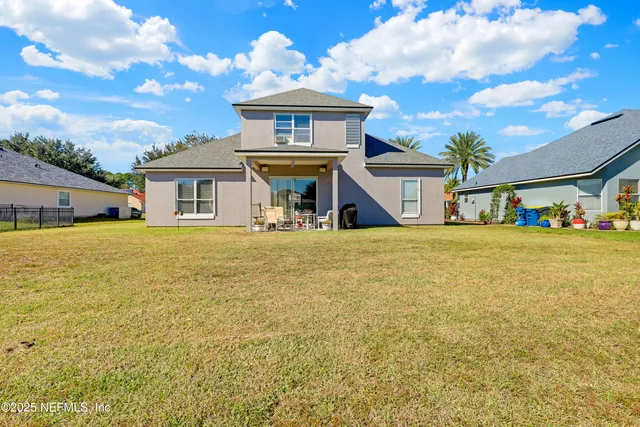 a view of house with a big yard and potted plants
