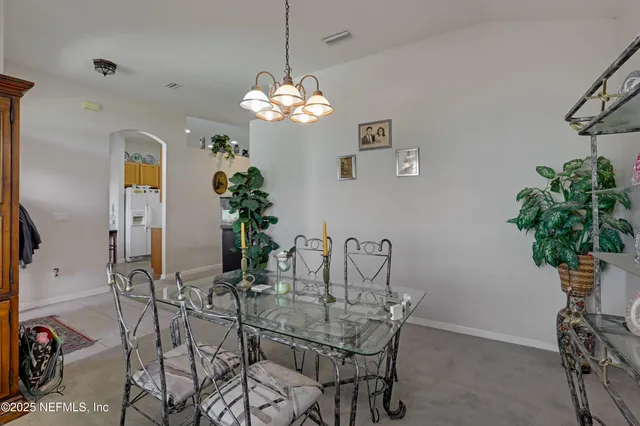 a view of a dining room with furniture and chandelier