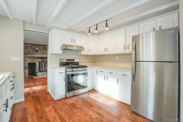 a kitchen with granite countertop a refrigerator and a stove top oven