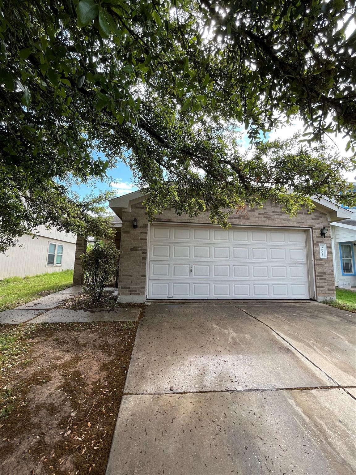 3001 Caleb Drive Austin, TX 78725 - Photo 2 of 16 View of front of property with concrete driveway, brick siding, and an attached garage