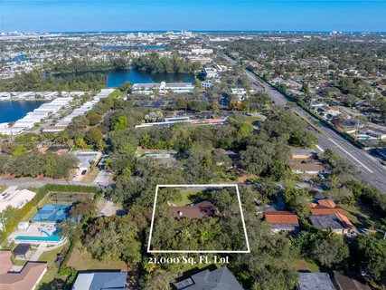 an aerial view of residential houses with outdoor space and lake view