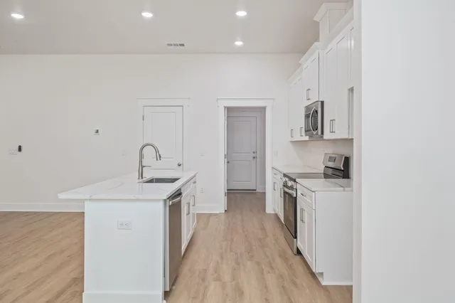 a kitchen with stainless steel appliances granite countertop a sink stove and refrigerator