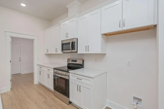 a kitchen with white cabinets and white appliances
