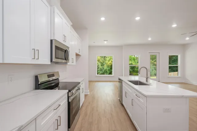a kitchen with sink a microwave and cabinets