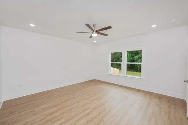 an empty room with a window and a fan