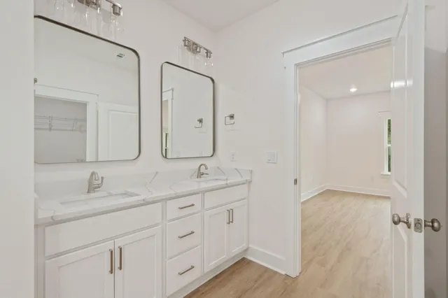 a bathroom with double sink and a mirror