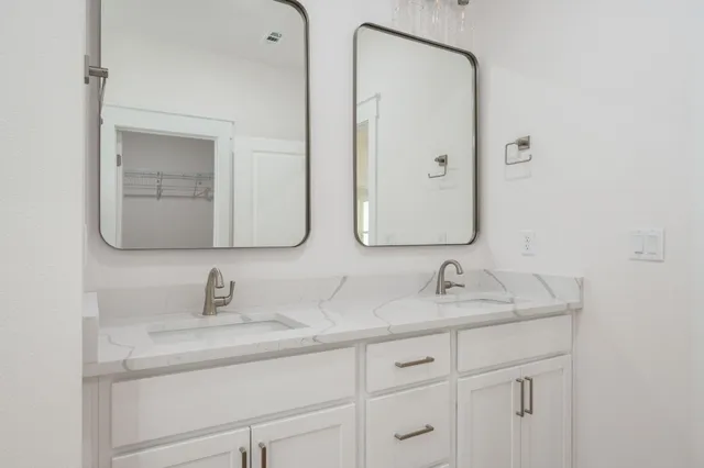 a bathroom with a double vanity sink and mirror